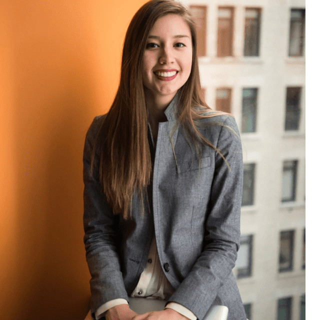 orange wall tiny tech fail businesswoman office tower suit jacket